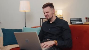 Talihsiz genç sakallı üzgün adam dizüstü bilgisayarı kullanıyor. Bilgisayarda arama yapıyor. Ani piyango sonuçları, kötü haberler, servet kaybı, başarısızlık. Oturma odasında kanepede oturan iş adamı.