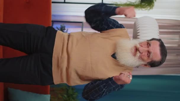 Счастливый Беззаботный Пожилой Человек Танцующий Дома Возле Дивана Выбирая Любимую — стоковое видео