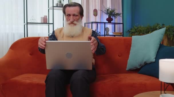 Старший Дедушка Сидит Диване Закрывая Ноутбук После Окончания Работы Гостиной — стоковое видео