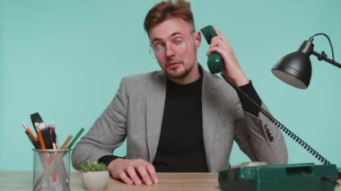 Hey sen, beni ara. Ofis masasında oturan mutlu sakallı bir iş adamı 90 'lı yılların telli telefonları ile konuşuyor. Reklam telefonları iletişimde. Mavi stüdyodaki genç çocuk