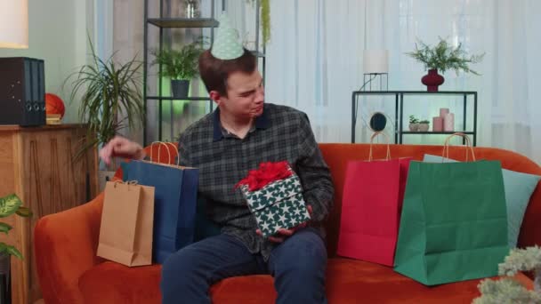 Gelukkig Student Man Draagt Feestelijke Verjaardag Pet Hoed Houden Geschenkdoos — Stockvideo