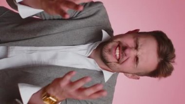 Samimi iş adamı 20 'li yaşlarda iyi şans diliyor ve kaybediyor. Aniden piyango sonuçları, kötü haber, servet kaybı şaşırıyor. Yetişkin erkek çocuk pembe arka planda izole edilmiş. Dikey