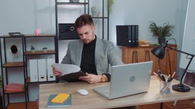 Stressed businessman in formal wear suit feeling worried about financial problem doing paperwork at office. Concentrated male freelancer man frustrated thinking of money debt, budget loss, bankruptcy