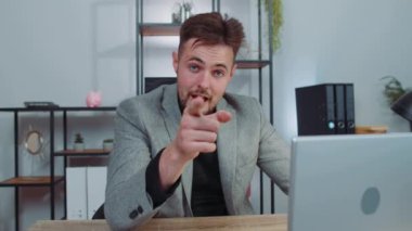 I choose you. Businessman programmer software developer working on office laptop pointing to camera, looking with happy expression, making choice, showing direction. Concentrated male freelancer man