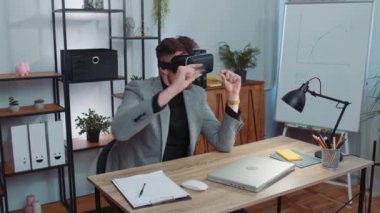 Businessman in suit working using virtual reality futuristic technology VR app headset helmet at home office. Freelancer man busy creating new architecture project. Remote education, study, learning