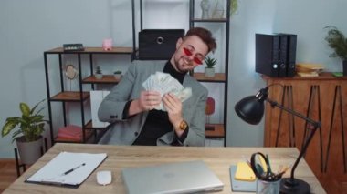 Zengin, takım elbiseli patron işadamı hayran, başarılı iş kariyeri, piyango talihlisi, büyük gelir ve servet gibi banknotlar sallıyor. Ev işyerinde serbest çalışan bir yönetici.