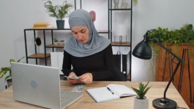 Bilgisayarda çalışan zengin bir iş kadını nakit para sayıyor, ofis işyerindeki gelir gelirlerini hesaplıyor. Profesyonel menajer, serbest çalışan kız. Müslüman insanlar. İstihdam, meslek