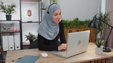 Kulaklık takarak dizüstü bilgisayarda çalışan iş kadını, serbest çalışan çağrı merkezi, destek operatörü yardım hattı, ofisteki müşteri ya da iş arkadaşı iletişim desteği ile hoş sohbetler