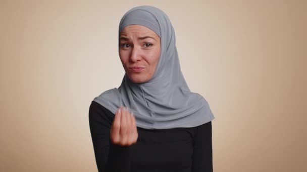 快乐而富有的千禧年女性在头巾中表现出挥金如土或挥金如土的样子 更多的小贴士梦想着大利润的身体语言 在米色工作室背景下被隔离的年轻穆斯林女孩 — 图库视频影像