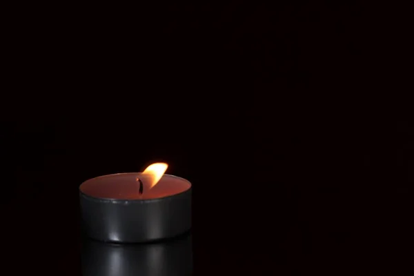 Burning candle on a black background — Stock Photo, Image