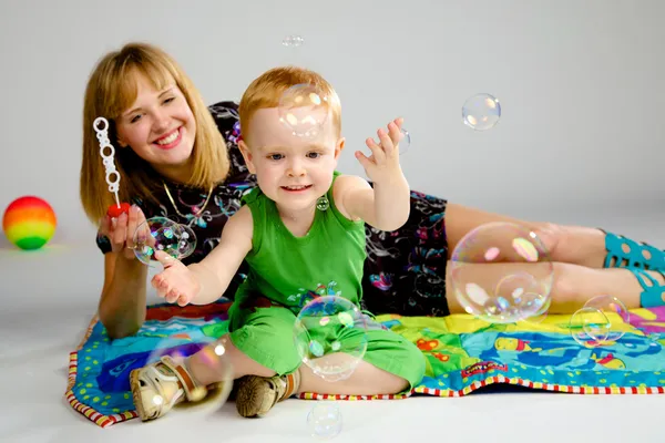 Mamma e figlio giocare con bolle di sapone — Foto Stock