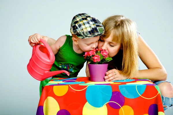 Madre e hijo regando flores con una regadera — Foto de Stock