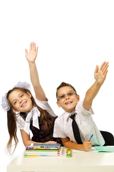 Um menino e uma menina na mesa levantaram as mãos — Fotografia de Stock