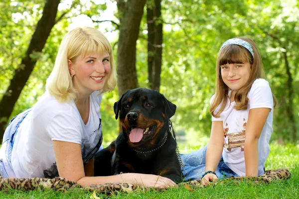 Woman, girl and dog on the grass. — Stock Photo, Image