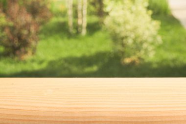 Boş ahşap tablo ya da raf, doğadan gelen soyut yeşil bokeh 'in bulanık görüntüsü, ürün görüntüleme montajına hazır.