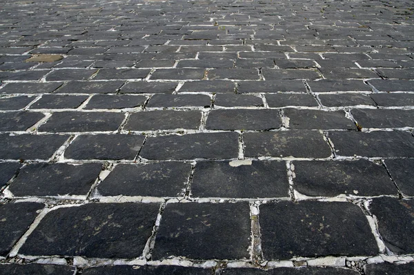 Black cobblestone background in perspective — Stock Photo, Image