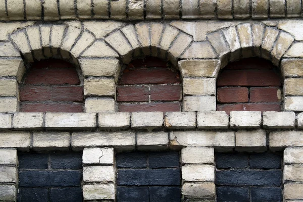 Oude bakstenen muur met drie niches — Stockfoto