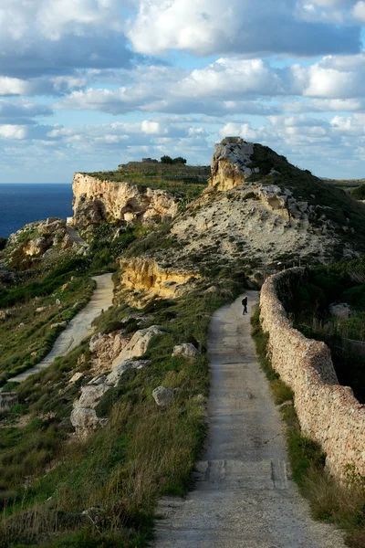 Een man wandelen in de bergen, bergen uitzicht met mooie bewolkte hemel op zonnige zomer in malta, manier om de rots met blauwe hemel, maltese landschap, Maltees aard, eiland landschap met hemelachtergrond, malta — Stockfoto