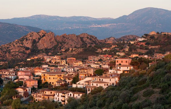 Santa Maria Navarrese village in Sardinia in warm sunrise light, Italy, typical sardinian seascape,sardinian village, sunrise in summer, warm colors in sunrise hours, village view in sunrise,mountains