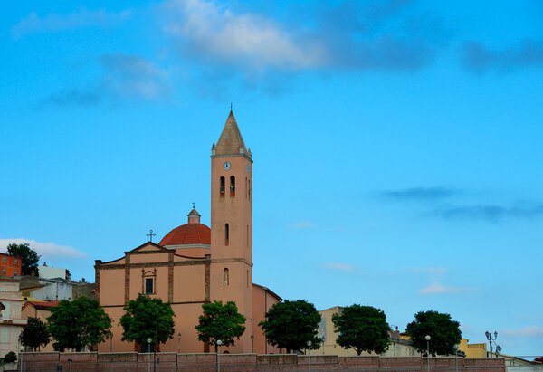 Bolotana village in Sardinia, Italy, St Peter Parish Church in Bolotana embellished with 19 century Neoclassic decor in cloudy sky background in sunset, sardinian church, mountain village, landmark

