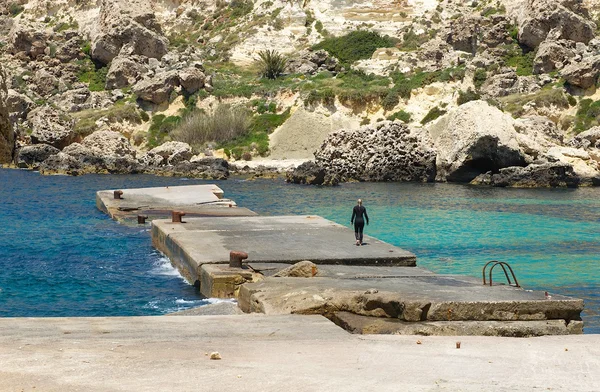 Villaggio Papay a Malta, costa maltese, baia maltese con mare cristallino e sfondo di roccia gialla, vacanze, donna in spiaggia, subacqueo, vacanza a Malta, subacqueo vicino al mare, attività estive — Foto Stock