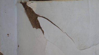 Beton duvar çöküyor. Çatlak beton eski duvar. tehlikeli, hasarlı bina yapısı.