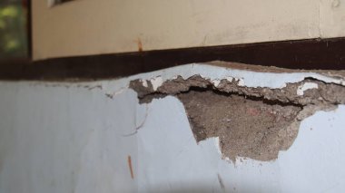 Beton duvar çöküyor. Çatlak beton eski duvar. tehlikeli, hasarlı bina yapısı.