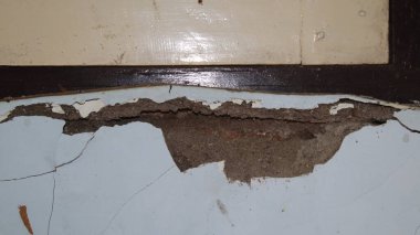 Beton duvar çöküyor. Çatlak beton eski duvar. tehlikeli, hasarlı bina yapısı.