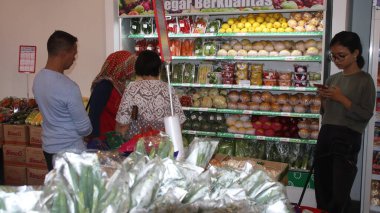 Virüs salgını sırasında alışveriş. Cerrahi maske takan insanlar süpermarketten mal alıyorlar. Aile dükkanda. Batang, 17 Ocak 2022