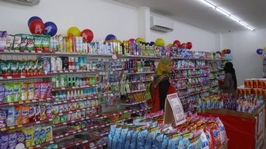 Virüs salgını sırasında alışveriş. Cerrahi maske takan insanlar süpermarketten mal alıyorlar. Aile dükkanda. Batang, 17 Ocak 2022