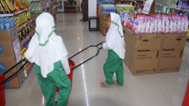 Virüs salgını sırasında alışveriş. Cerrahi maske takan insanlar süpermarketten mal alıyorlar. Aile dükkanda. Batang, 17 Ocak 2022