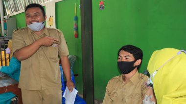 Kamu görevlisi, 14, 2022 tarihli Endonezya, Batang aşısı yaptırıyor.