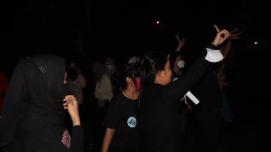 10 Aralık 2021, Salatiga, sahada dans ederek ve gece eğlenerek müzikle eğlenen bir grup insan.