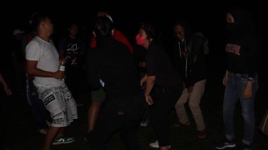 10 Aralık 2021, Salatiga, sahada dans ederek ve gece eğlenerek müzikle eğlenen bir grup insan.