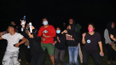 10 Aralık 2021, Salatiga, sahada dans ederek ve gece eğlenerek müzikle eğlenen bir grup insan.