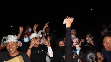 10 Aralık 2021, Salatiga, sahada dans ederek ve gece eğlenerek müzikle eğlenen bir grup insan.