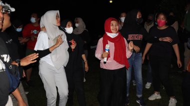 10 Aralık 2021, Salatiga, sahada dans ederek ve gece eğlenerek müzikle eğlenen bir grup insan.