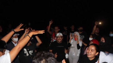 10 Aralık 2021, Salatiga, sahada dans ederek ve gece eğlenerek müzikle eğlenen bir grup insan.