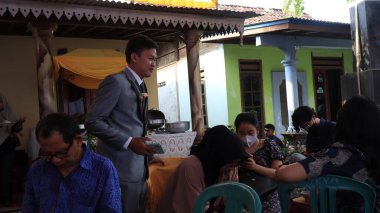 Guests enjoying a traditional wedding party, Kendal, Indonesia, 6 July, 2022