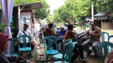 Guests enjoying a traditional wedding party, Kendal, Indonesia, 6 July, 2022