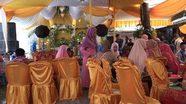 Guests enjoying a traditional wedding party, Kendal, Indonesia, 6 July, 2022