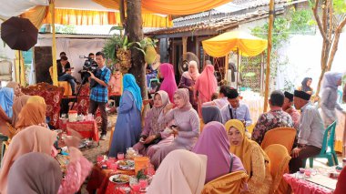 Guests enjoying a traditional wedding party, Kendal, Indonesia, 6 July, 2022