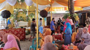 Guests enjoying a traditional wedding party, Kendal, Indonesia, 6 July, 2022