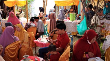 Guests enjoying a traditional wedding party, Kendal, Indonesia, 6 July, 2022