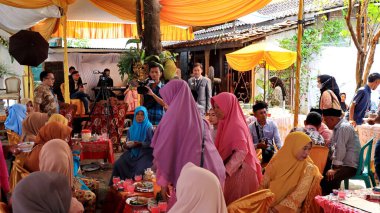 Guests enjoying a traditional wedding party, Kendal, Indonesia, 6 July, 2022