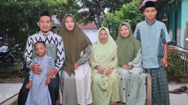 Muslim family taking a group photo, to celebrate Eid al-Fitr 