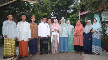 Muslim family taking a group photo, to celebrate Eid al-Fitr 