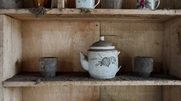 Close up old wooden cupboard with dirty, dusty and old clay pots