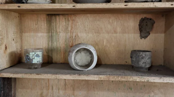 Close up old wooden cupboard with dirty, dusty and old clay pots