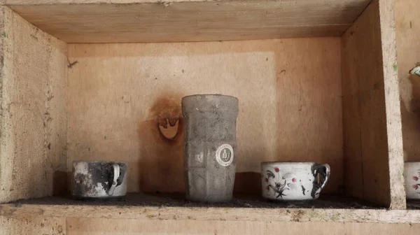 Close up old wooden cupboard with dirty, dusty and old clay pots